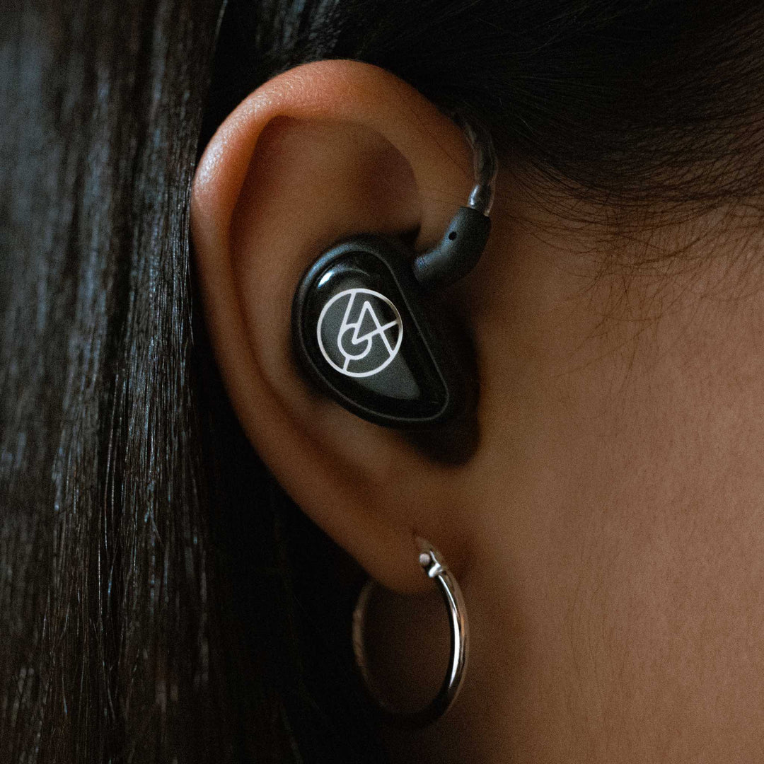 64 Audio Aspire 4 closeup inserted into human ear with attached cable