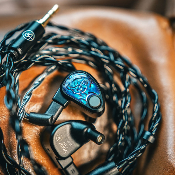 64 Audio Volür with coiled attached cable on leather couch from Bloom Audio gallery
