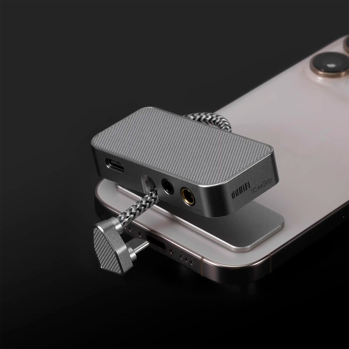 ddHiFi TC44Grip DAC dongle floating above attraction pad attached to iphone on black background