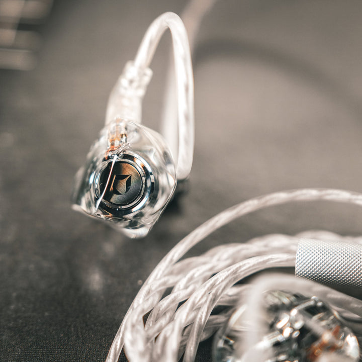 DITA Audio Project M single earphone extreme closeup with attached coiled, stock cable