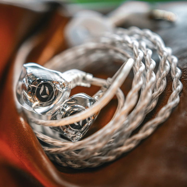 DITA Audio Project M extreme closeup with attached coiled, stock cable over brown leather
