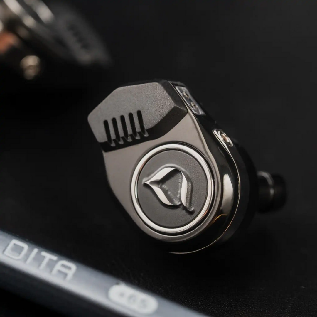DITA Audio Ventura IEM sitting front closeup of logo with DITA pencil on black background