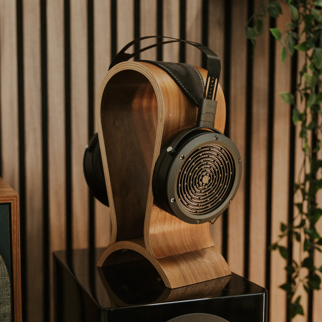 DUNU Arashi front quarter on headphone stand with plant atop gloss black loudspeaker