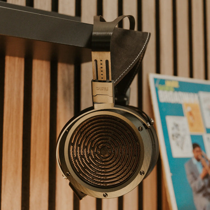 DUNU Arashi right profile hanging on corner of shelf with vinyl record Bokeh