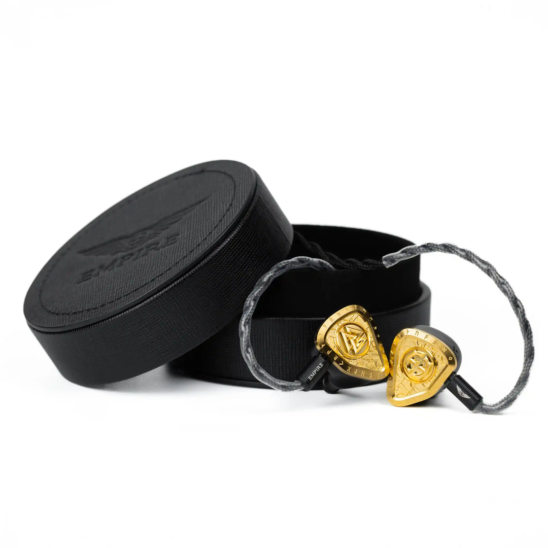 Empire Ears Odin MKII IEMs coming out of round black leather case attached to cable front facing whitebox