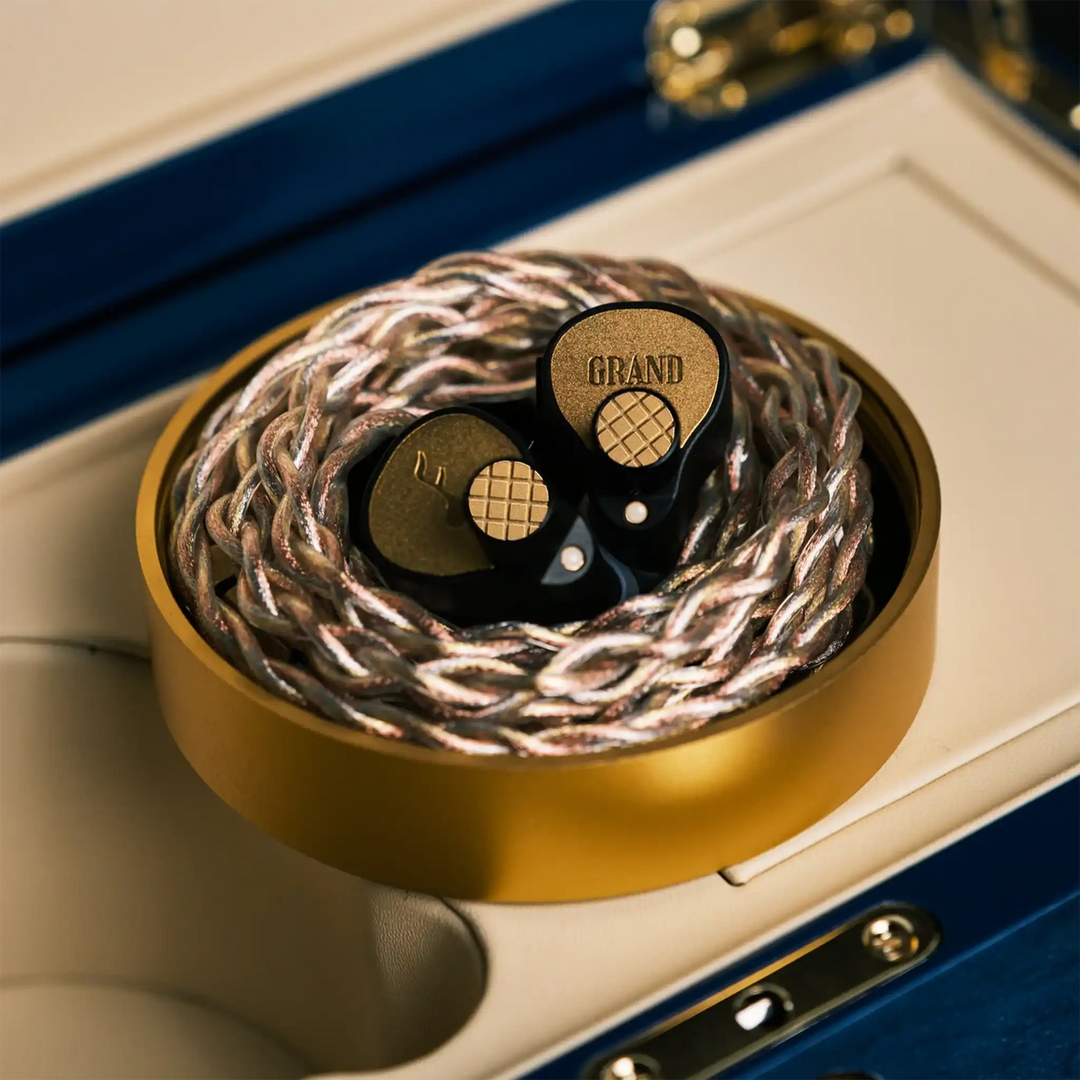FATfreq Grand Maestro Limited Edition IEMs sitting in gold case with coiled Origin cable on open Anniversary box