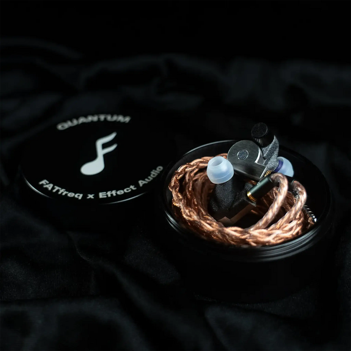 FATfreq x Effect Audio Quantum iems wrapped with cable sitting on metal case next to lid with logo on black satin background
