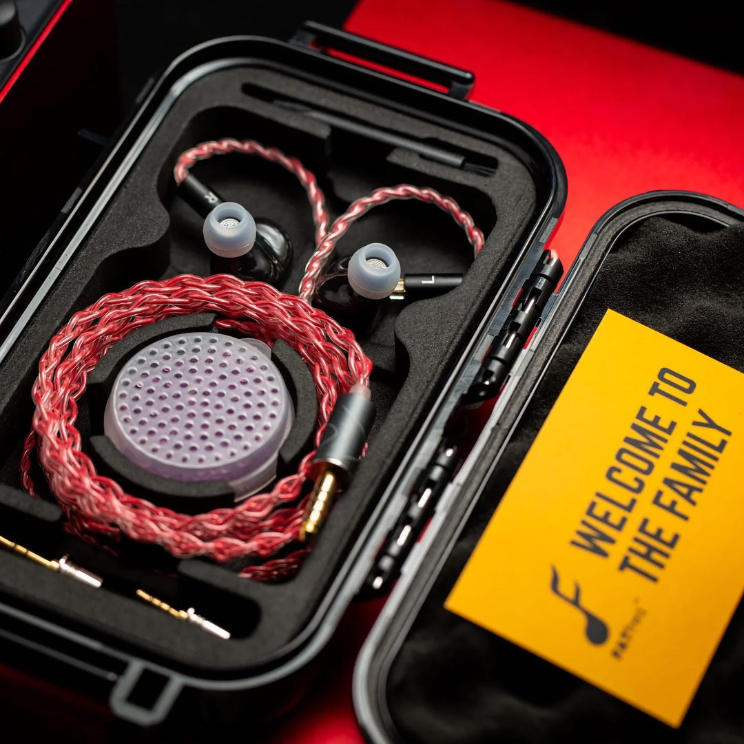 FATfreq Scarlet Mini with attached coiled stock cable inside open carry case with accessories next to red amplifier