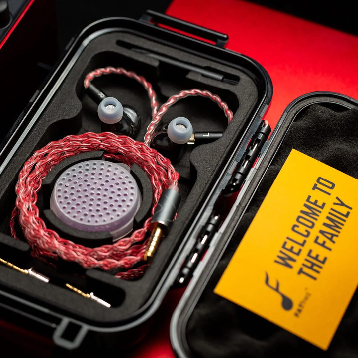 FATfreq Scarlet Mini with attached coiled stock cable inside open carry case with accessories next to red amplifier