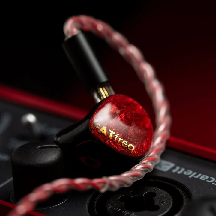 FATfreq Scalet Mini left earphone with attached silver-red cable bokeh effect