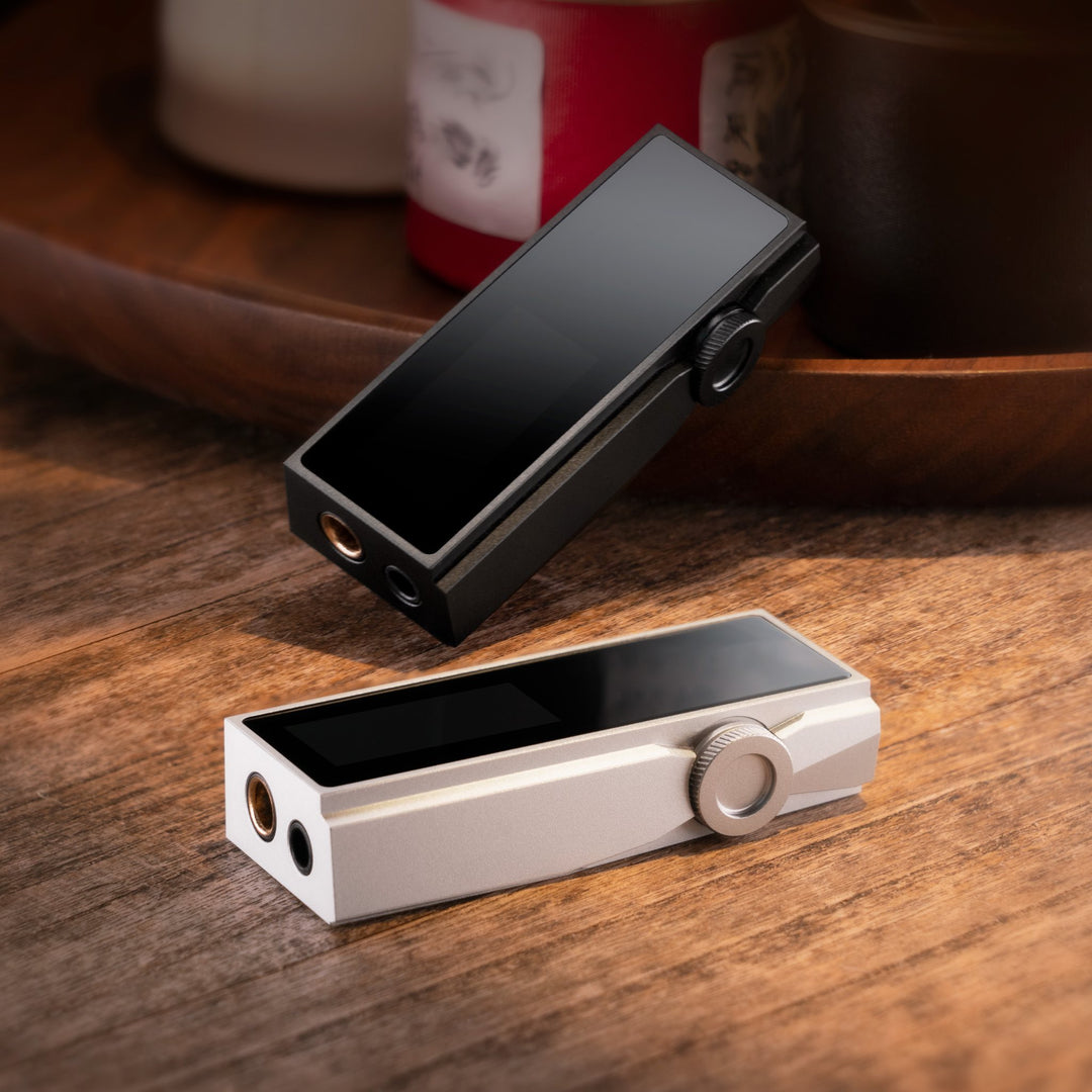 iBasso DC07Pro black and silver dongles on wood table with wood plate