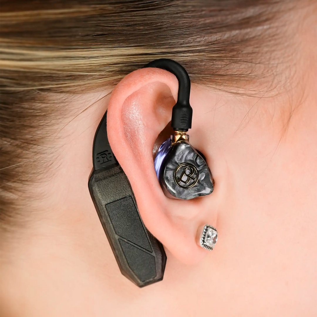 iFi Audio single GO pod Air dac and amp sitting in woman's right ear with IEMs attached