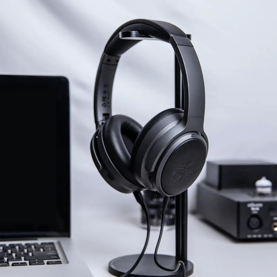 Kiwi Ears Ardor headphones sitting on headphone stand on desk with headphone amplifier and open laptop