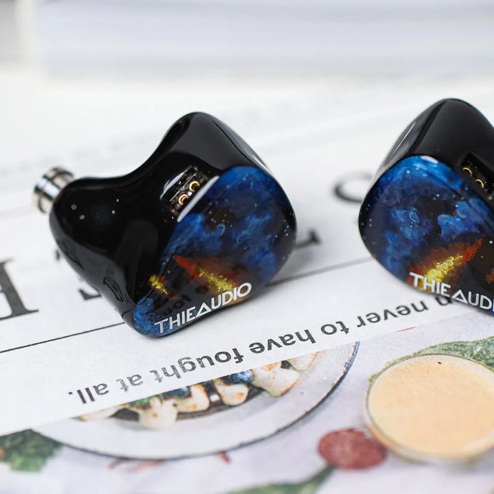ThieAudio Origin earphones high angle over news print