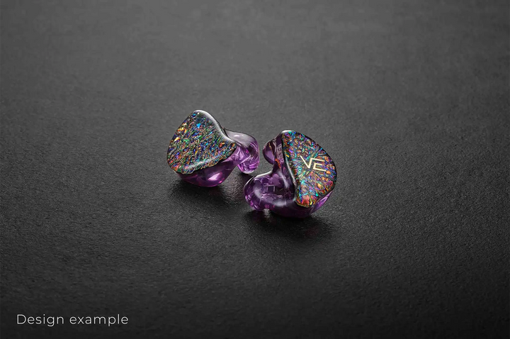 Vision Ears VE ONE IEMs sitting slightly diagonally colorful faceplate purple shell facing out on dark grey background