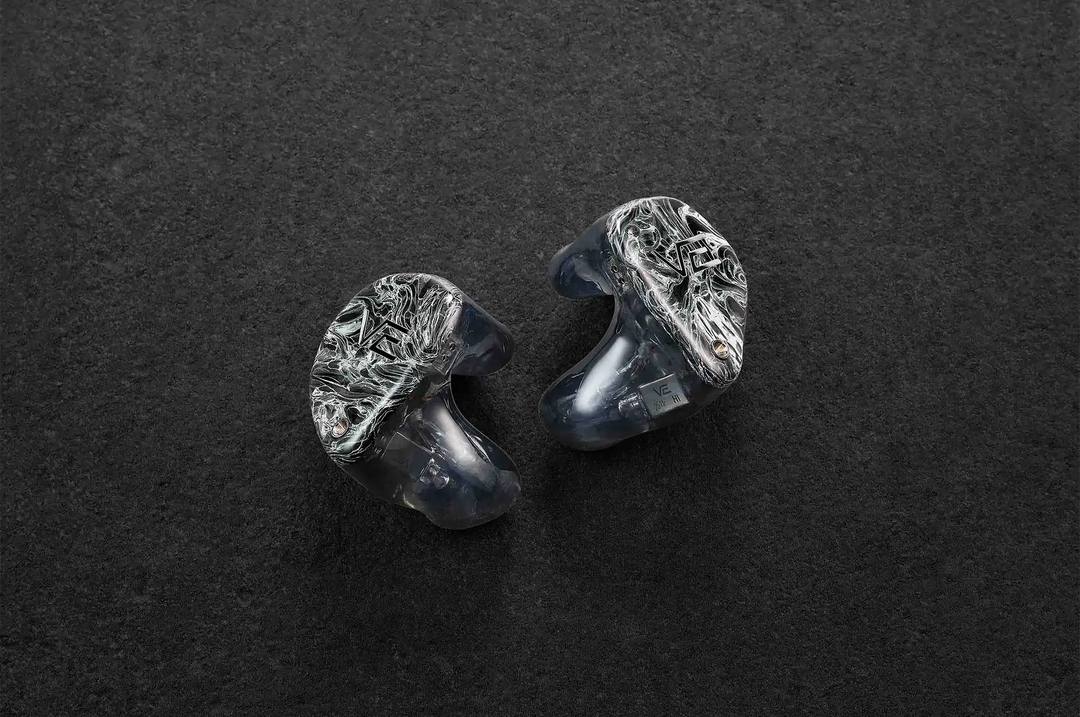 Vision Ears VE ONE IEMs sitting slightly diagonally faceplate facing out on dark grey background