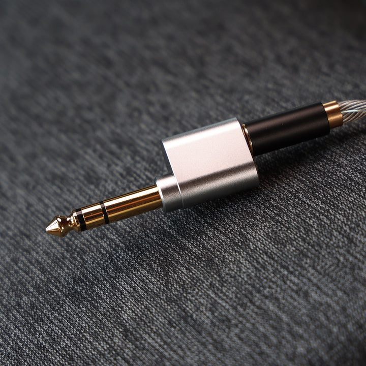 ddHiFi DJ65B(AL) with inserted headphone cable over dark cloth background