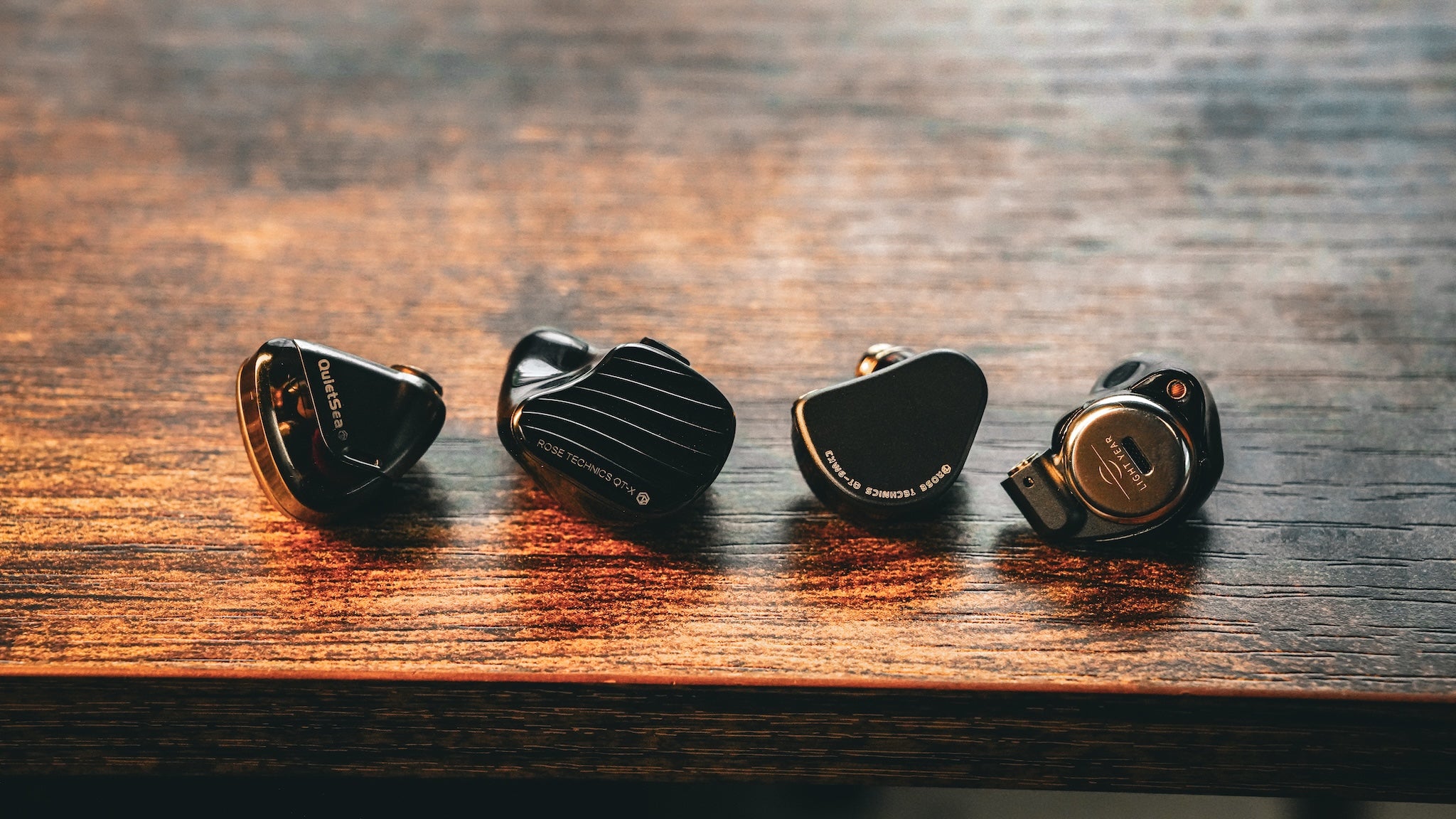 Rose Technics IEMs on a wooden desk 