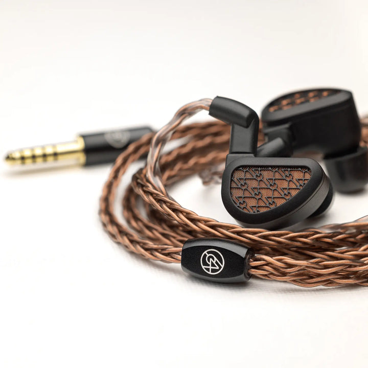 64 Audio Solo earphones with attached coiled stock cable whitebox Bokeh