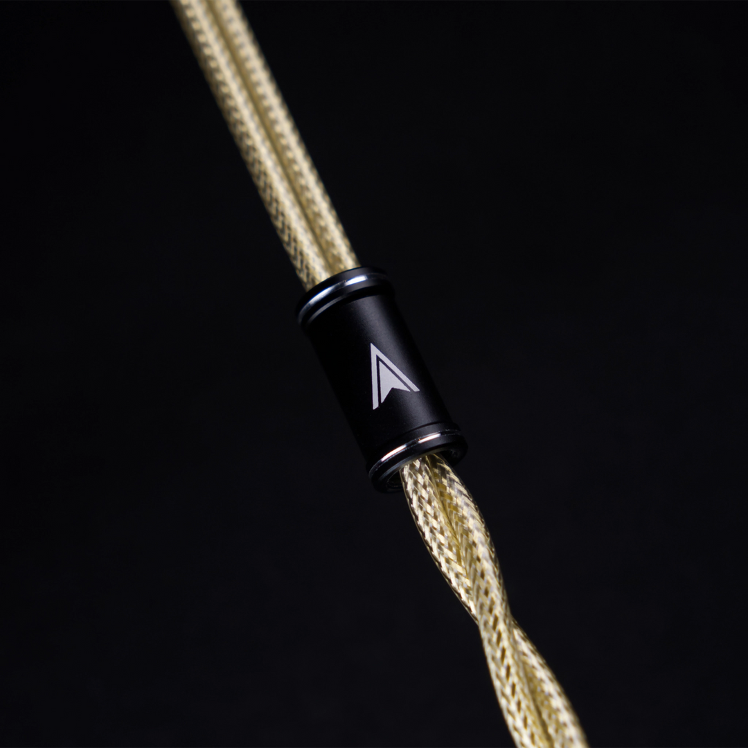 Astral Acoustics Sol 26 cable  close-up braided gold cable secured with a matte black metal connector set against solid black background