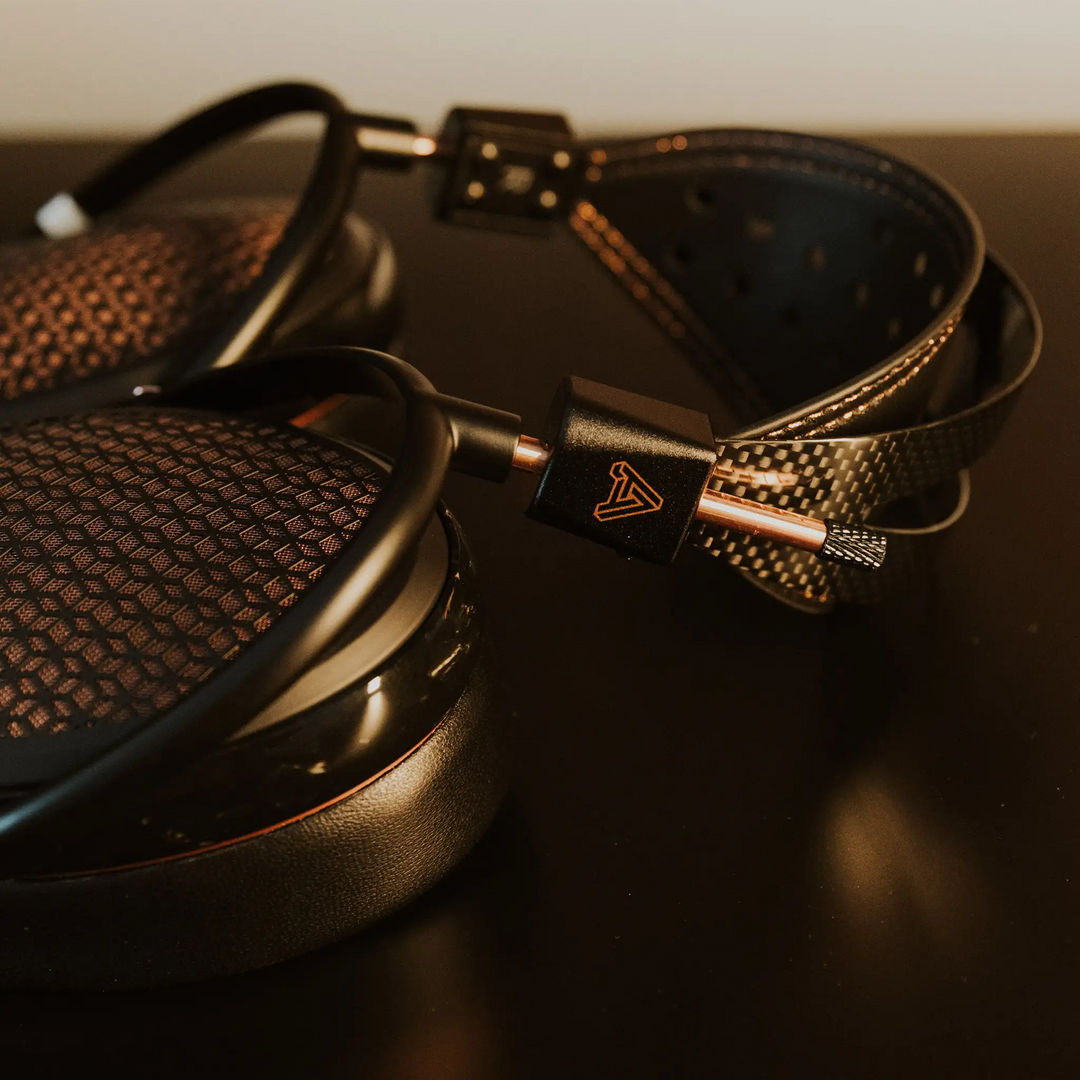 Audeze CRBN2 headphones closeup of metal components lying on black metal table