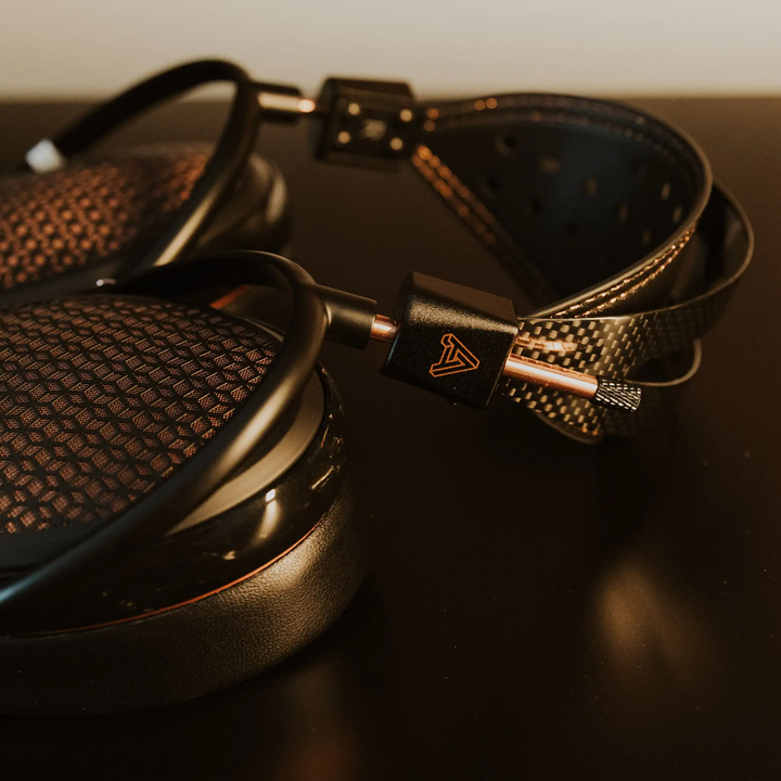 Audeze CRBN2 headphones closeup of metal components lying on black metal table