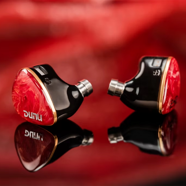 DUNU DN242 iems sitting facing outward center on red reflective background