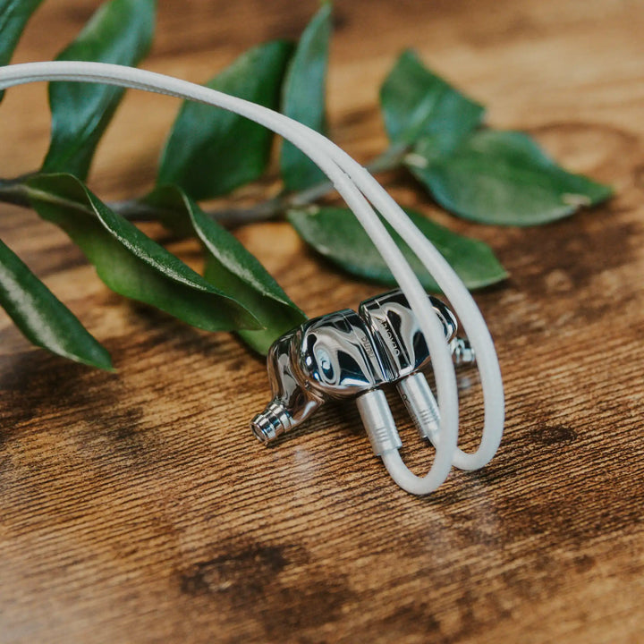 DUNU Glacier closeup with attached stock cable with plant leaf over wood table