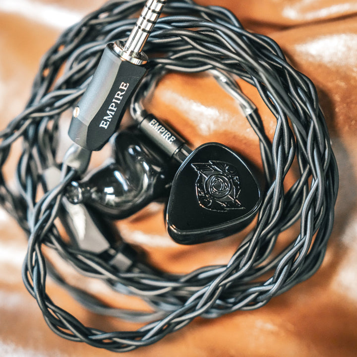 Empire Ears Raven black with attached coiled cable on leather couch from Bloom Audio gallery