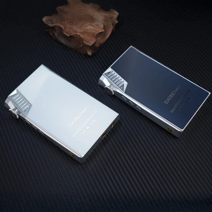 iBasso DX260MK2 DAP in silver and white silver lying face down Birdseye view on black surface with wooden sculpture
