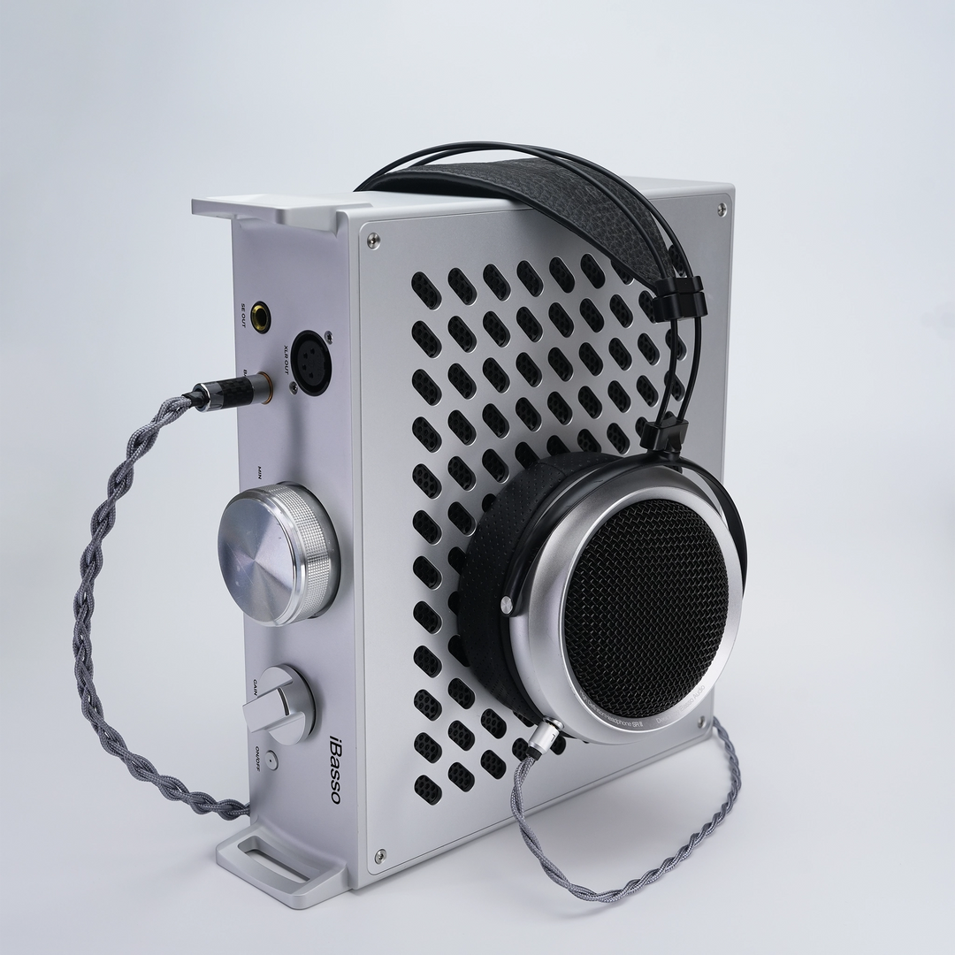 iBasso Kunlun desktop amplifier sitting on side with iBasso SR3 headphone sitting onto plugged in whitebox