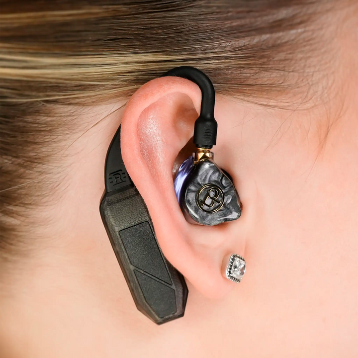 iFi Audio single GO pod Air dac and amp sitting in woman's right ear with IEMs attached