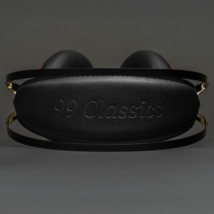 Meze 99 Classics 2nd Gen headphones lying down eye level view of headband with 99 classics logo on grey background