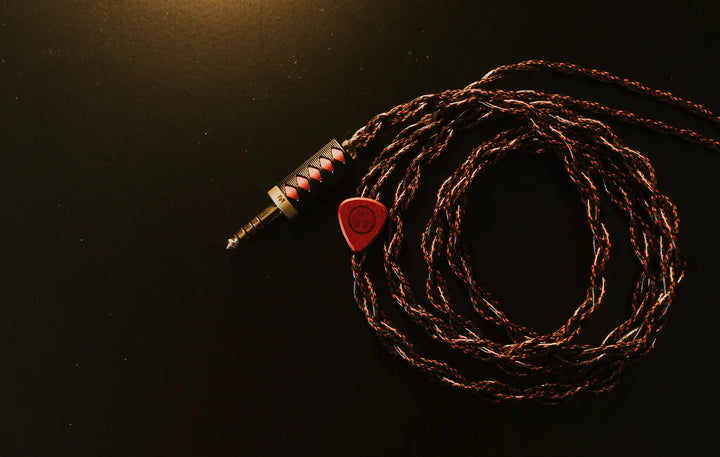 Noble Audio Shogun Cable wrapped in circle Birdseye view on black metal table
