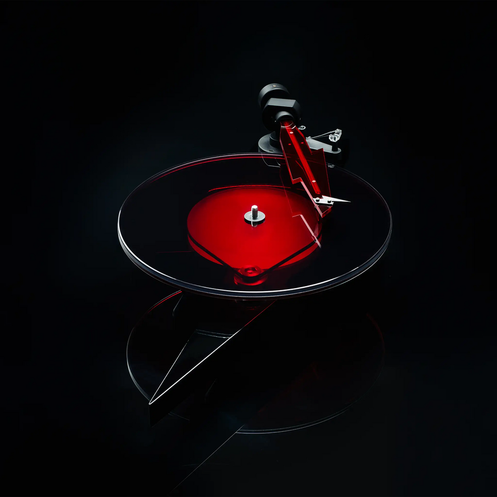 Pro-Ject AC/DC turntable center top down angle sitting on reflective black backdrop