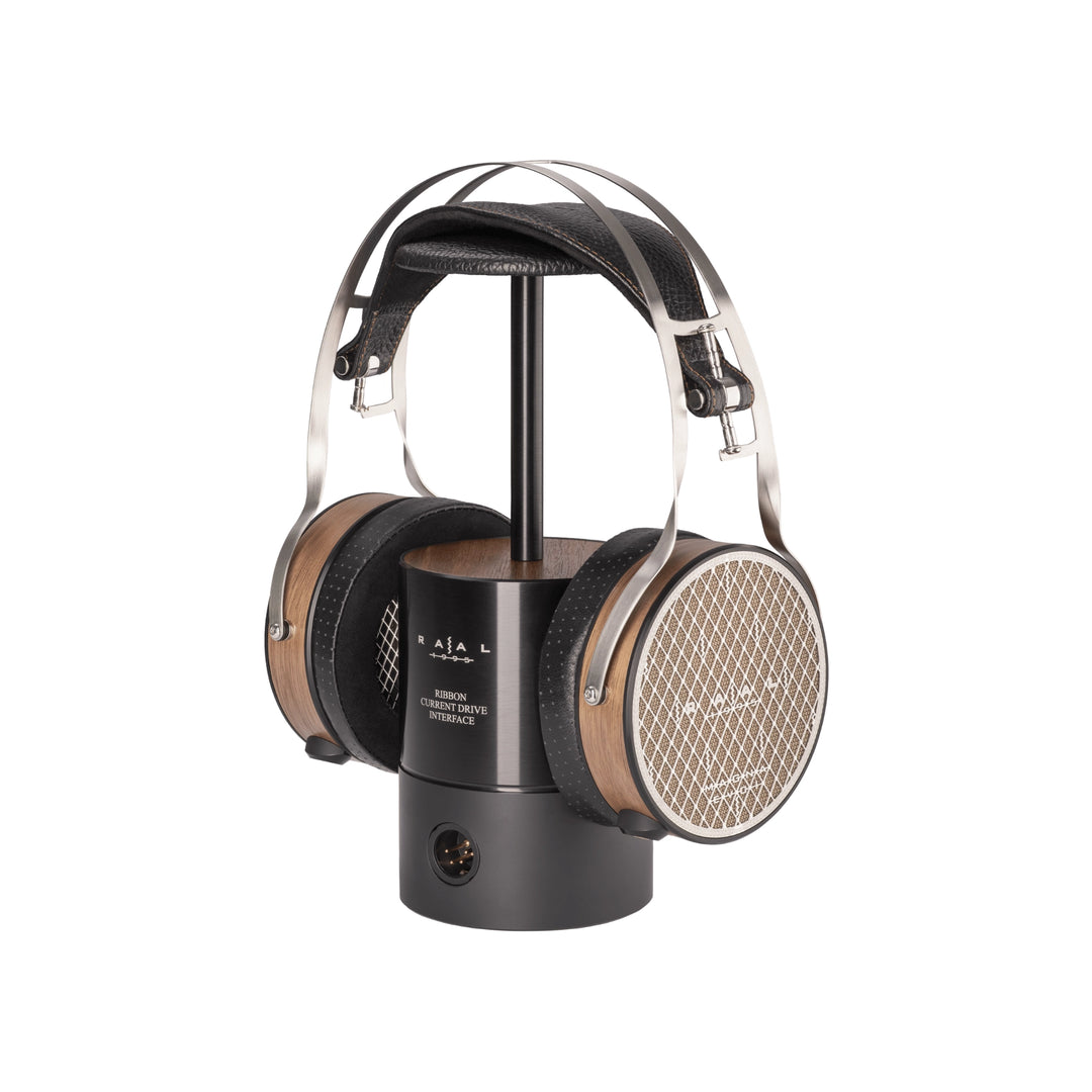RAAL 1995 Magna Evo I over-ear headphones displayed on a black stand against a solid white background.