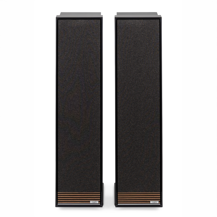Ruark Audio Talisman R speakers with dark textured fabric fronts, slim black frames, and copper-toned horizontal grille accents near the bottom, shown side by side on a white background.