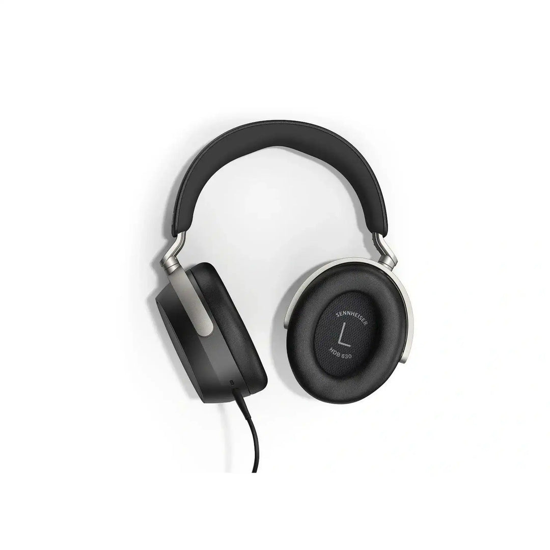 Sennheiser HDB 630 headphones lying front facing with left ear cup rotated with ear pad showing whitebox