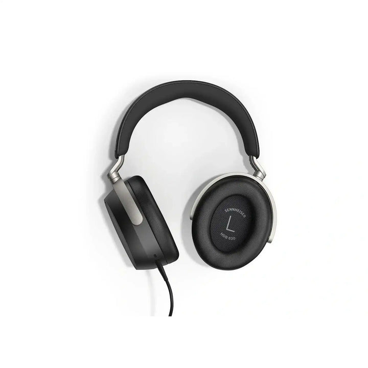 Sennheiser HDB 630 headphones lying front facing with left ear cup rotated with ear pad showing whitebox