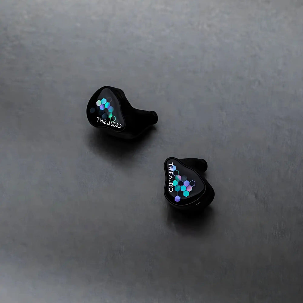 Thieaudio Monarch MKIV IEMs with octagon faceplate sitting diagonally face up on grey background
