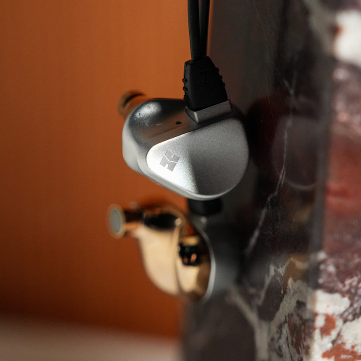 HiFiMAN Svanar with attached cable hanging from marble obelisk
