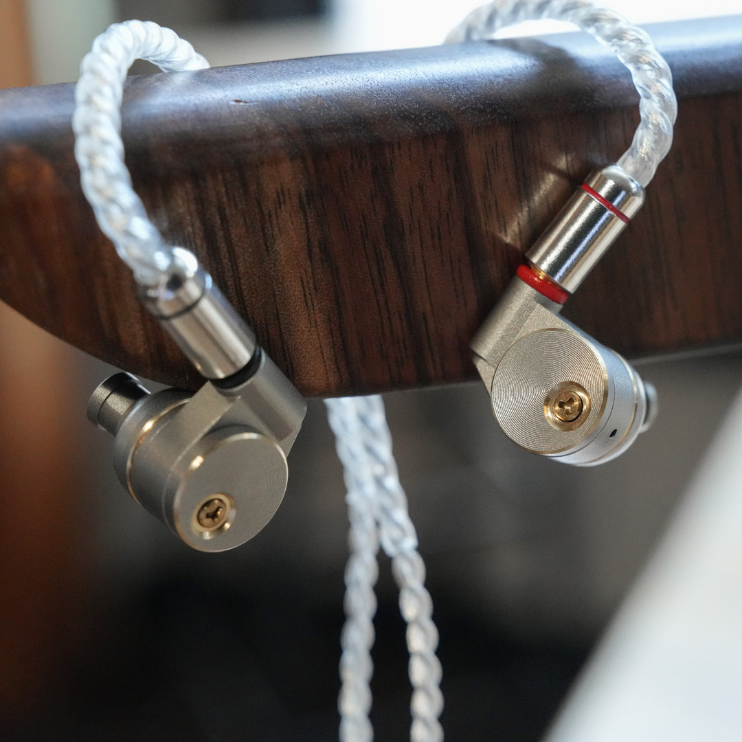 Ucotech RE-2 earphones with attached cable over wood stand from Bloom Audio gallery